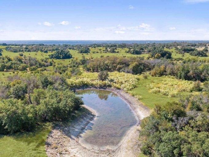 arial shot of Miller Creek Ranch with a water tank and acreage with trees in Lampasas County Texas as a listing with Texas Ranch Brokers