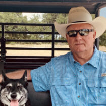 greg collins with his dog in a side by side utility vehicle on a ranch in texas